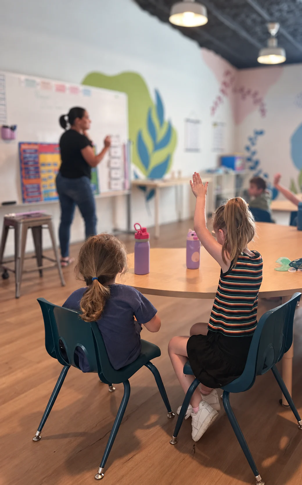 A teacher leading ROC Academy students in prayer during class