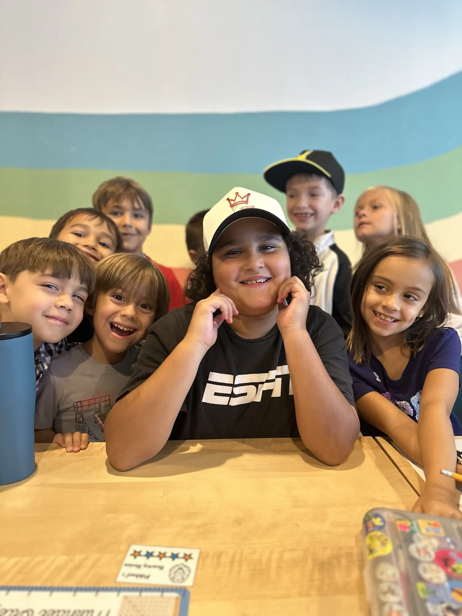 ROC Academy students smiling together around a classroom table